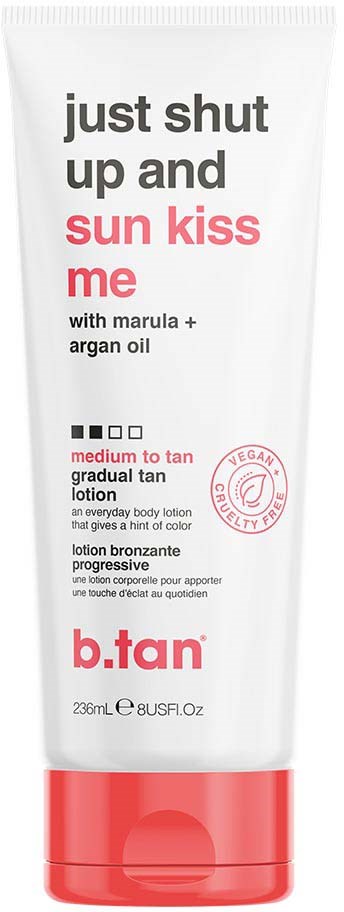 En hvit flaske med bruntende lotion med rød og svart tekst, som indikerer at den gir gradvis bruning med marula og arganolje.