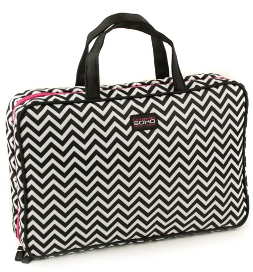 En reiseveske med svart-hvitt zigzag-mønster, svarte håndtak og en rosa glidelås. Lite merke på forsiden.