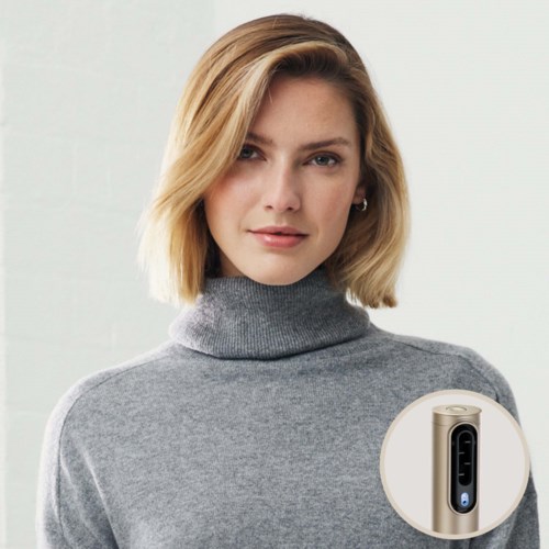 En kvinde med skulderlangt blondt hår iført en grå turtleneck. Et billede af en lille beige hudplejeenhed med digital skærm.