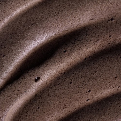Nahaufnahme von Schokoladenschaum mit glatten, gewölbten Texturen und kleinen Bläschen.