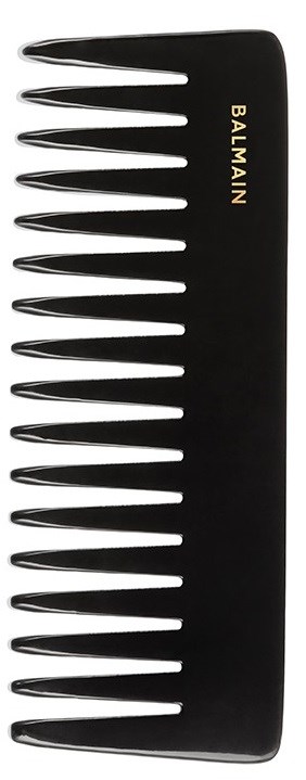 En svart hårkam med brede tenner, ordet 'BALMAIN' skrevet i gull. Kammen har en buet form.
