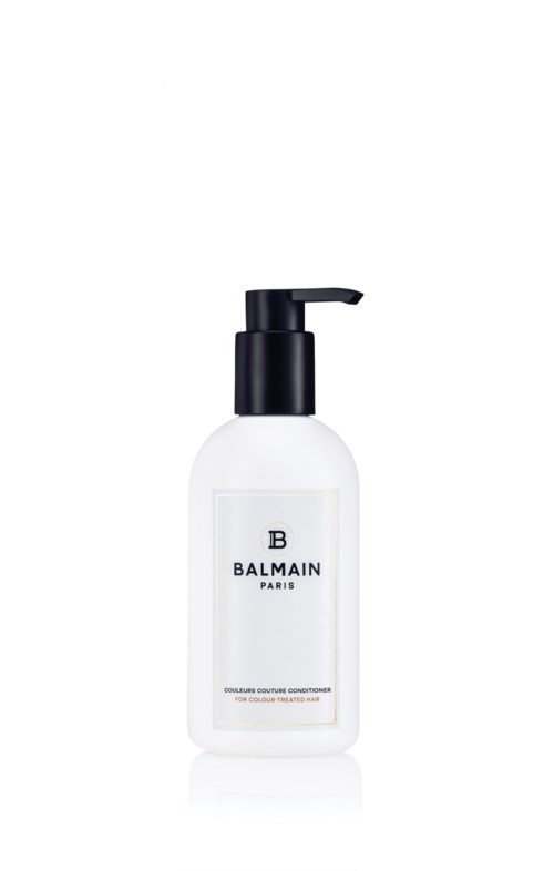 En hvit flaske med svart pumpe merket Balmain Paris, sannsynligvis et hår- eller kroppsprodukt.
