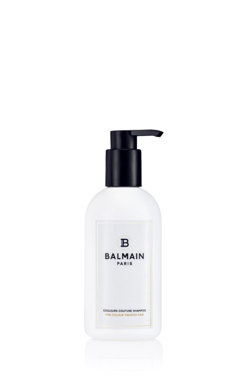 En hvit flaske med svart pumpe merket Balmain Paris, sannsynligvis sjampo eller dusjsåpe.
