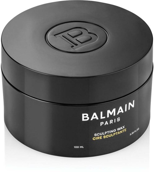 En sort rund beholder med låg, mærket 'Balmain Paris Sculpting Wax.' Den indeholder 100 ml voks.