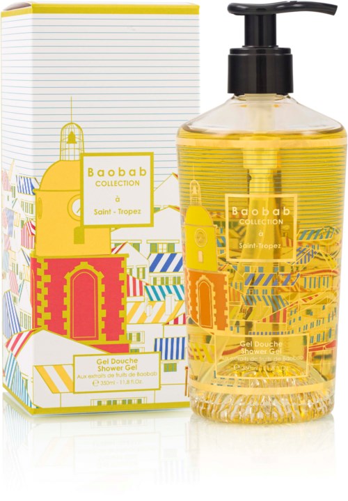 A clear yellow shower gel bottle with a black pump, next to a colorful box with seaside illustrations.