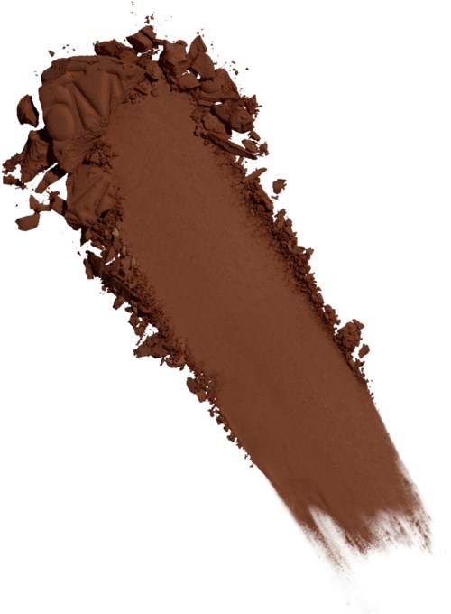 Brunt pulver spridd med några spridda bitar, liknar makeup eller färg.
