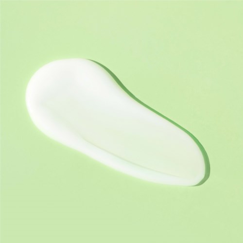 A white, rounded soap or lotion bar on a light green background.