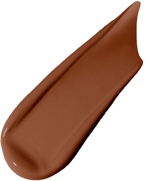 En klick av brun krämig röra, slät och förlängd, på en vit bakgrund.