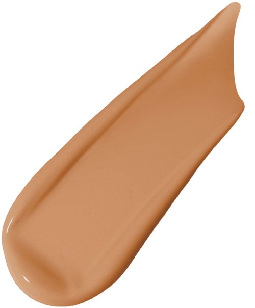 En bit av beige flytande foundation med en slät, krämig textur bredvid en böjd tygkant.