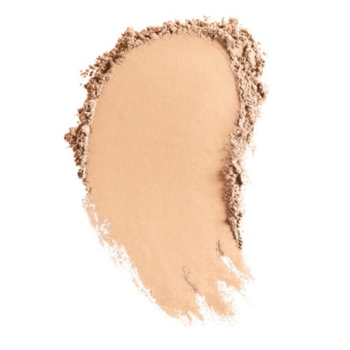 En beige pulver som är utbredd i en oregelbunden form, med en ojämn kant. Ser ut som ett ansikts- eller sminkpuder.