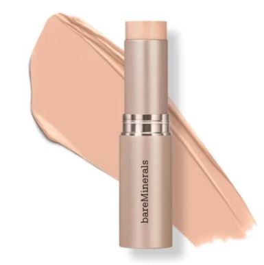 Beżowa sztyftka podkładu BareMinerals z próbką produktu w tle.