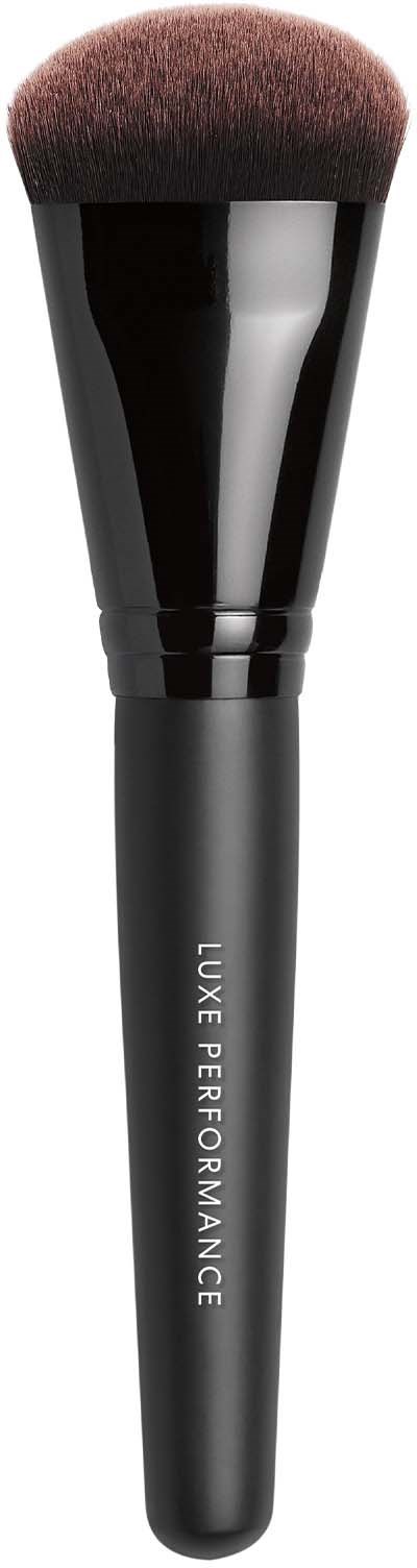 En svart makeupborste med mjuka borst som är märkt "LUXE PERFORMANCE" på handtaget.