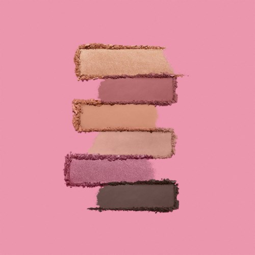 Seks forskellige nuancer af pink og lilla øjenskygge swatch på en pink baggrund.