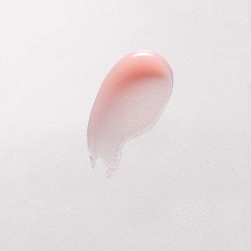 En tydlig gel med rosa ton är på en enkel vit yta, formad som en droppe.
