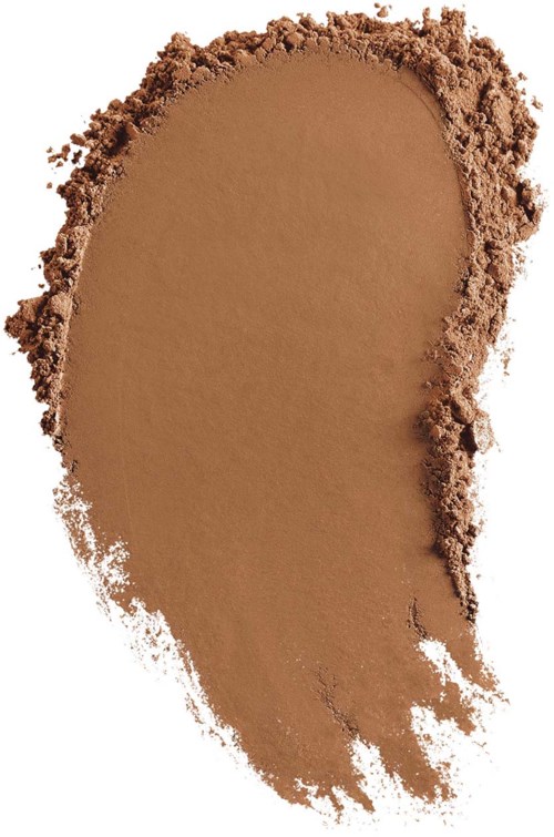 A large patch of brown powder spread on a white background, with uneven edges and some loose particles around.