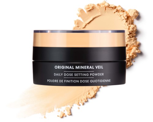 En svart rund behållare med mineral veil-puder med ett beige märke på toppen, puder spillt runt den.