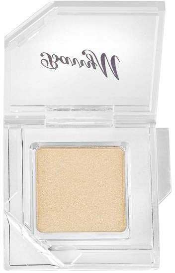 Ett beige sminkprodukt i en klar plastkapsel med varumärket 'Winnie' på locket.