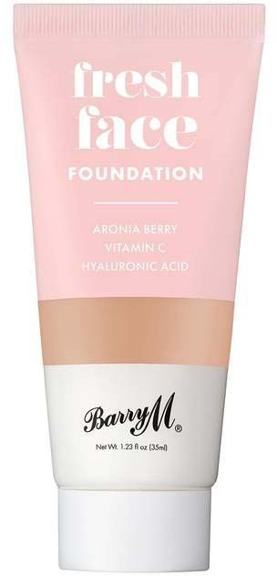 En rosa tube med foundation, hvit seksjon, merke Barry M, og ingredienser som aroniabær og vitamin C.