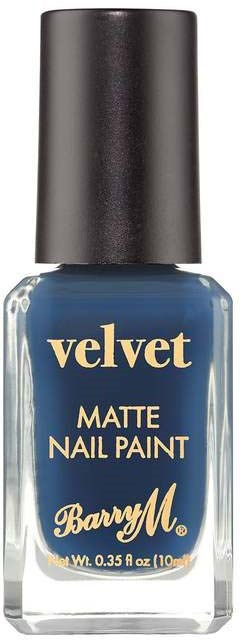 En nagellackflaska i mörkblått med svart kork, märkt 'velvet MATTE NAIL PAINT' av Barry M.