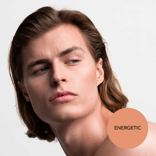 Tjej med långt hår som tittar åt sidan, lugnt uttryck, och en brunsfärgad etikett säger 'ENERGETIC.'