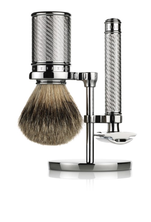 En rakborste och rakhyvla som står på en metallisk och texturerad ställning, håller en rakborste och en rakhyvel.