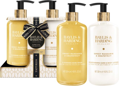 Set of four yellow hand and body care bottles, decorated with black and gold labels, with a gift box. Mellow citrus scent.