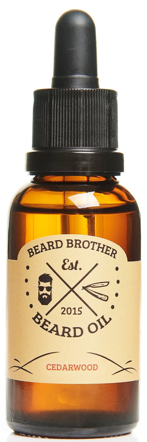En liten brungul glasflaska med dropparlock märkt 'Beard Oil' och 'Cedarwood', från Beard Brother, grundat 2015.