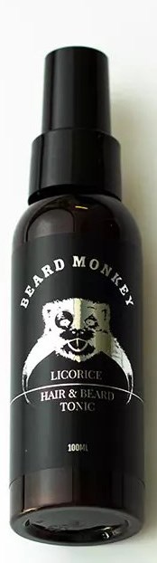 En mørk flaske mærket 'Beard Monkey' med en abeansigt, indeholder skæg- og håroller, 100 ml.