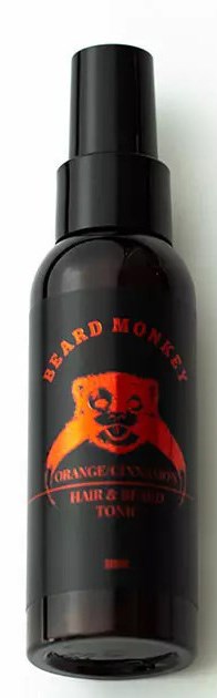 En sort sprayflaske med en rød og orange bjørne logo og tekst, mærket 'Beard Money.'