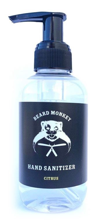 En klar flaska med en svart pump, märkt 'Beard Monkey' handsprit, med en apa och ordet 'Citrus'.