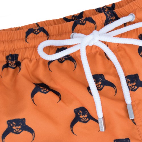 Orange badshorts med svart tigeransikte-mönster och vit snörning.