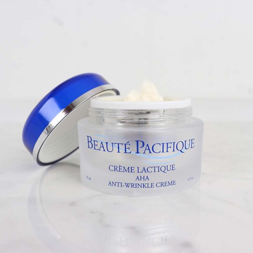 En vit burk med anti-rynkräm med blå lock, märkt 'Beauté Pacifique' och 'Creme Lactique AHA'.