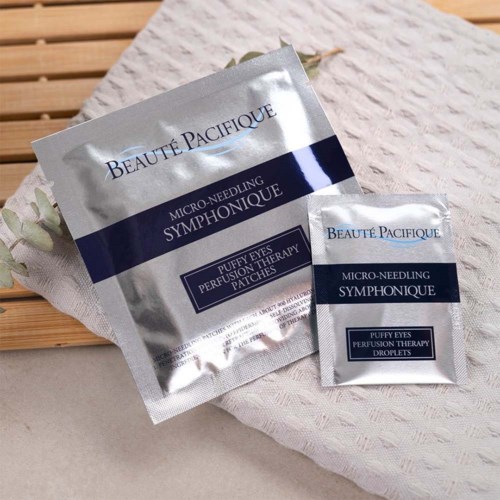 To sølvposer med Beauté Pacifique mikro-needling patches på hvid tekstil med træbaggrund.