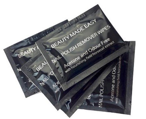 Tre svarta påsar märkt 'Nail Polish Remover Wipes' med aceton och doftfri. De ligger staplade på varandra.