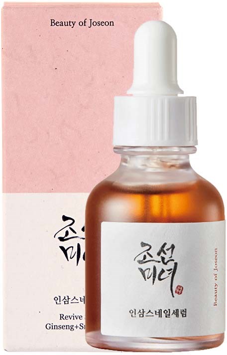 En liten brun flaska med vit pipettlock och etikett med koreansk text. Den står framför rosa förpackning.