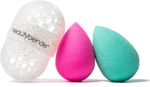 Three beauty blender sponges in pink, blue, and a white one with colorful specks. The white sponge has "beautyblender" written on it.
