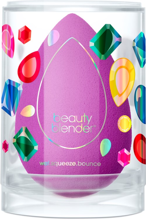 En lila beauty blender i ett tydligt lock med färgglada juvelliknande dekorationer runt den.