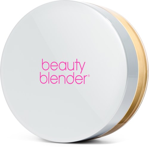 En rund vit sminkduk märkt 'beauty blender' med en guldkant som syns från sidan.