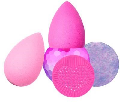 Fyra färgglada sminksvampar i rosa, lila och blå, med olika former och texturer.