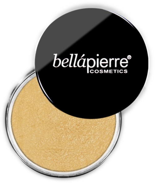 En liten rund sminkeholder med svart lokk som viser Bellápierre Cosmetics-logoen. Lokket er åpnet, og gyllent pulver er synlig inni.