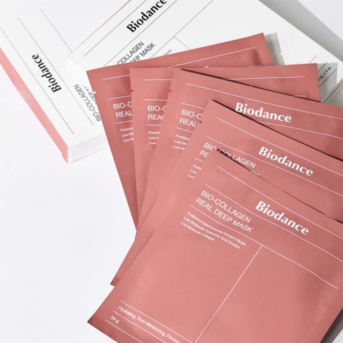 Useita pinkkejä Bio-­Collagen naamioita on fanned out valkoiselle paperille. Lähellä on samantapainen laatikko.