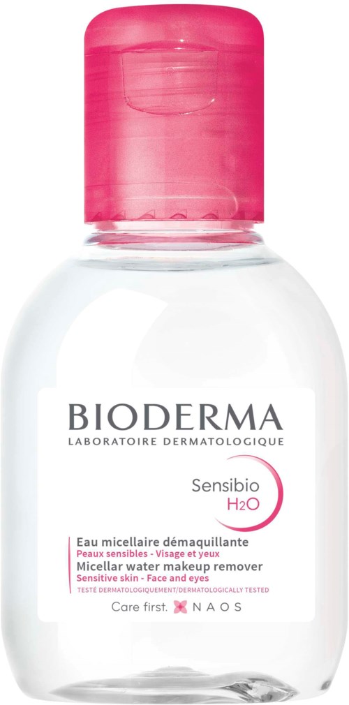 En liten genomskinlig flaska med rosa lock, märkt som Bioderma micellärrens för känslig hud, ansikte och ögon.