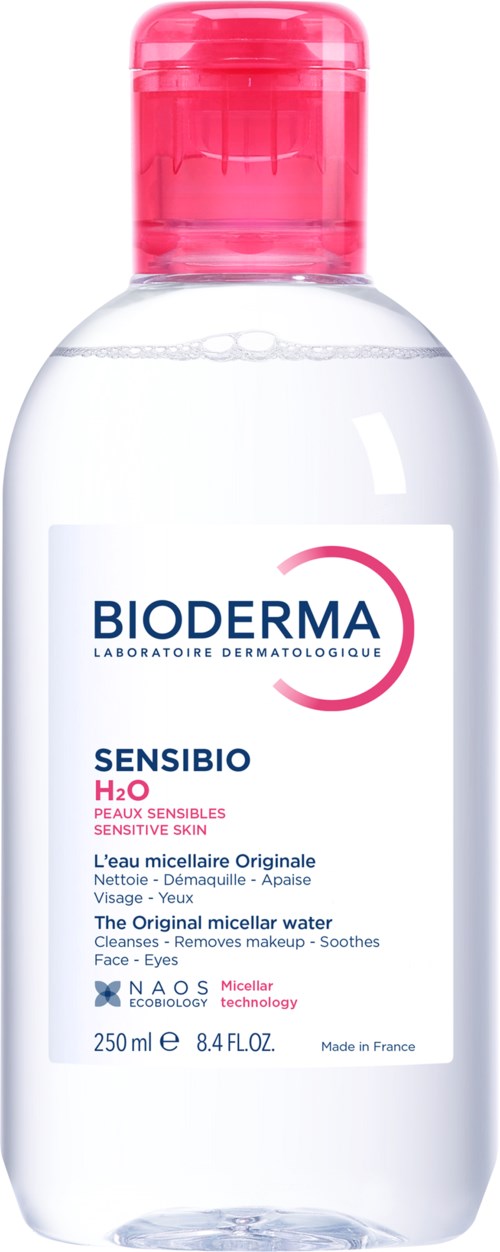 En genomskinlig flaska med rosa lock, märkt Bioderma Sensibio H2O, används för att rengöra känslig hud.