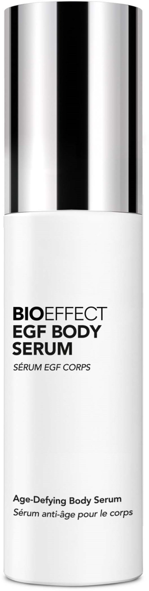 Valkoinen pullo, jossa kiiltävä hopeakorkki, nimeltä Age-Defying Body Serum mustalla ja harmaalla tekstillä.