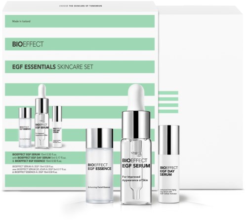 En hudplejesæt inkluderer flere flasker serum, mærket for forbedret hud og anti-age, med grøn og hvid emballage.