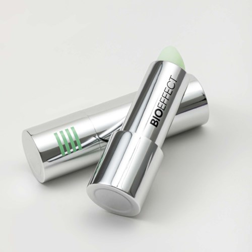 Två silver läppbalsamrör med gröna accenter, ett öppet med ljusgrön balm, märkt BIOEFFECT.