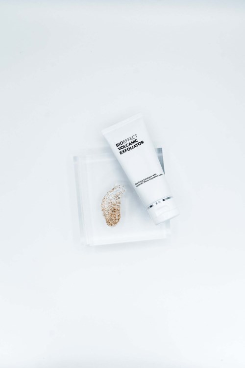 A white tube labeled 'Rescue' with a small pile of grains on a clear tray, on a white background.