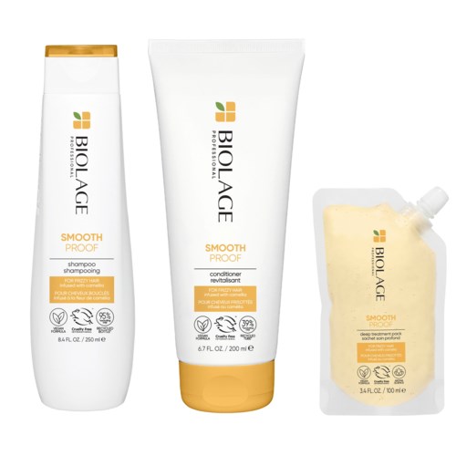 Tre Biolage schampo, balsam och hårmaskförpackningar med vit och orange design.