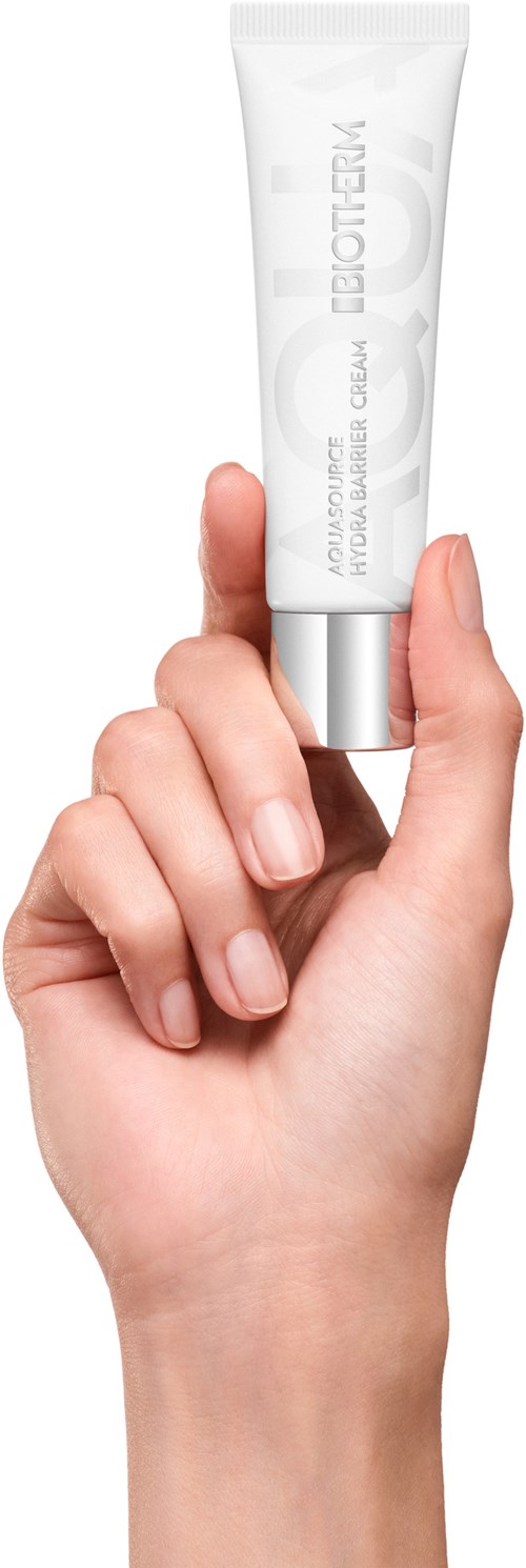 En hand håller en vit tub med silverlock, märkt Light Therapy, mot en enkel bakgrund.