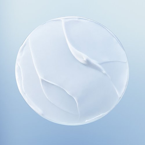 A clear, round, flat contact lens with curved lines inside. It appears smooth and shiny, floating above a light blue background.